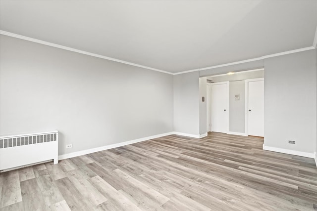 empty room featuring ornamental molding, light hardwood / wood-style floors, and radiator heating unit