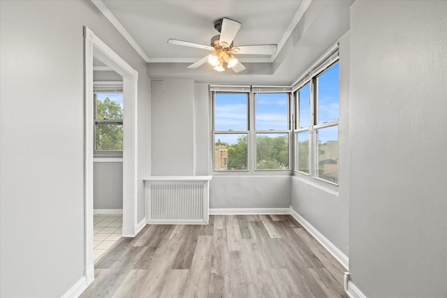 empty room featuring ornamental molding, ceiling fan, a healthy amount of sunlight, and radiator