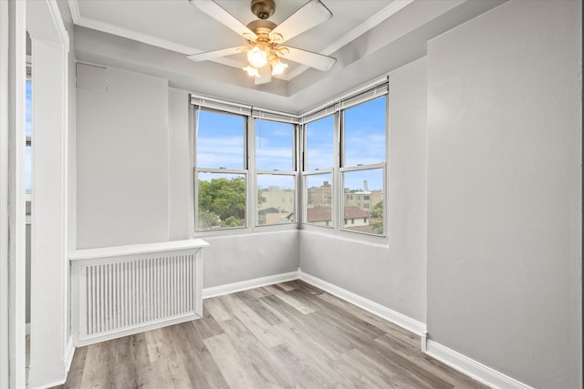 unfurnished room featuring ornamental molding, ceiling fan, light hardwood / wood-style floors, and radiator