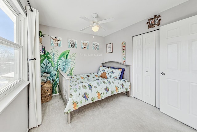 carpeted bedroom with ceiling fan and a closet