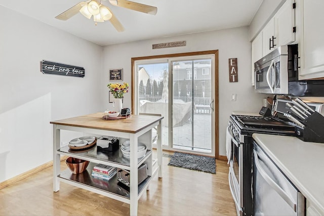 kitchen featuring white cabinetry, ceiling fan, stainless steel appliances, and light hardwood / wood-style flooring