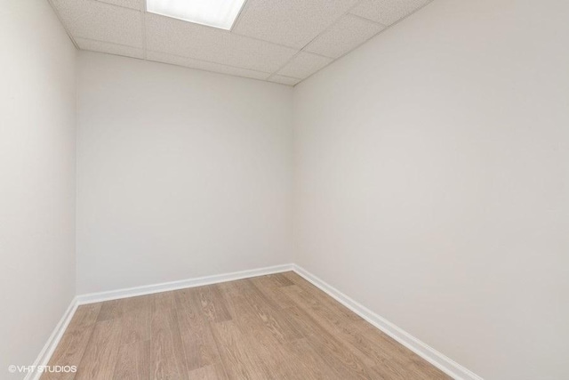 spare room with a drop ceiling and hardwood / wood-style floors