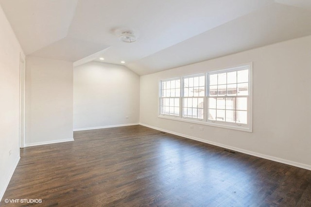 empty room with lofted ceiling and dark hardwood / wood-style flooring