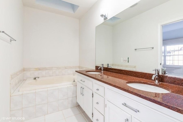 bathroom with tile patterned floors, tiled tub, and vanity