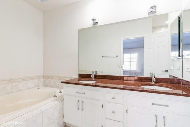 bathroom with tiled bath and vanity