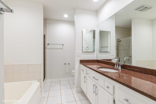 full bathroom featuring toilet, vanity, tile patterned floors, and separate shower and tub