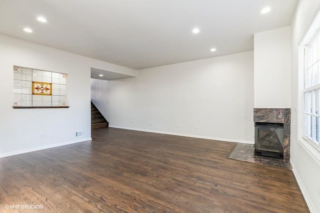 unfurnished living room with dark hardwood / wood-style flooring, plenty of natural light, and a fireplace