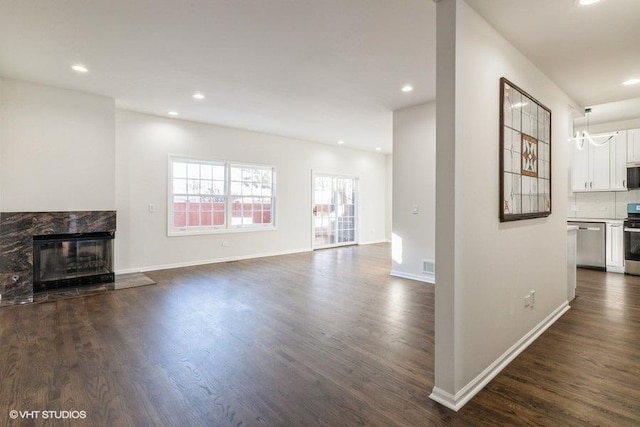 unfurnished living room featuring dark hardwood / wood-style flooring and a high end fireplace