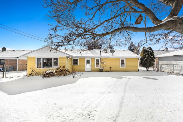 snow covered property with central air condition unit