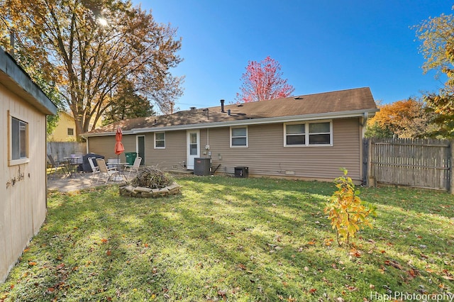 back of property with a lawn, a patio area, and central AC unit