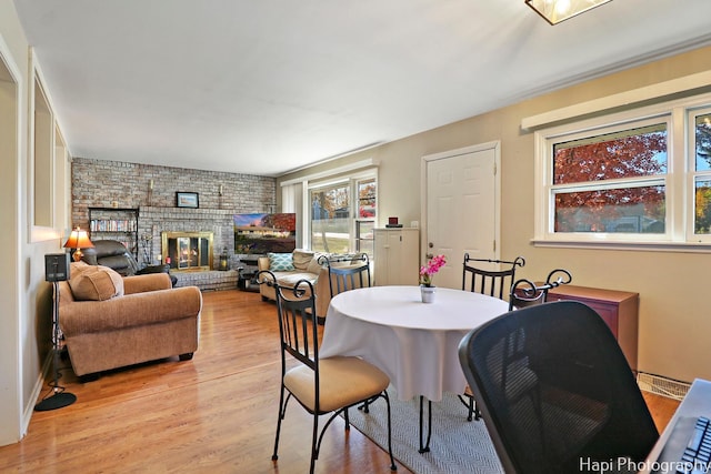 dining space featuring light wood-type flooring and a fireplace