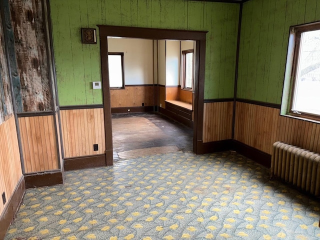 carpeted spare room featuring radiator