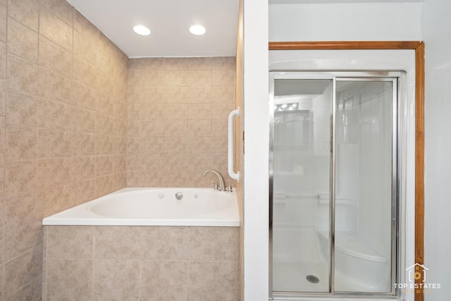 bathroom featuring independent shower and bath and tile walls