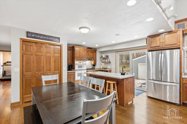 dining room featuring sink, hardwood / wood-style floors, and a textured ceiling