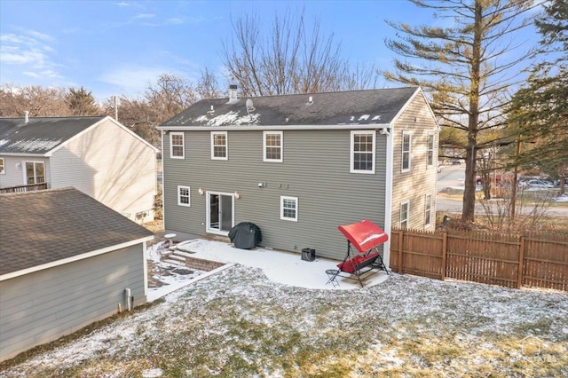 view of snow covered back of property