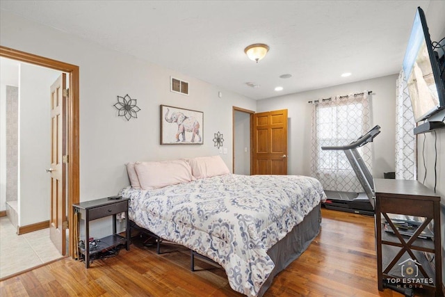 bedroom featuring connected bathroom and wood-type flooring