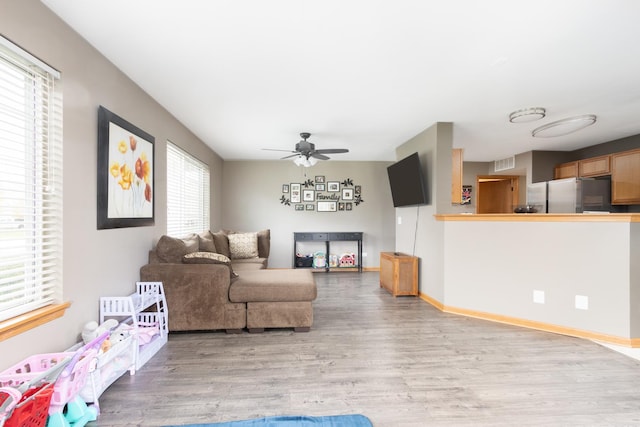 living room featuring light wood-type flooring and ceiling fan