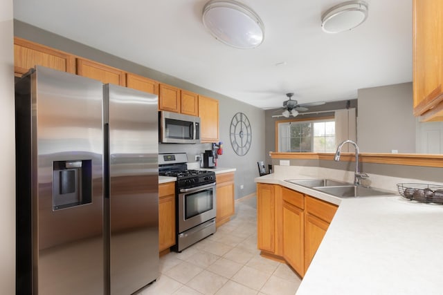 kitchen with sink, stainless steel appliances, light tile patterned flooring, and ceiling fan