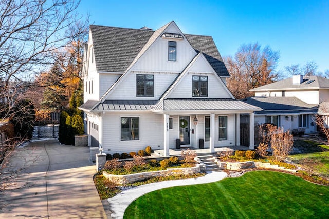 view of front of home with a garage, covered porch, and a front yard