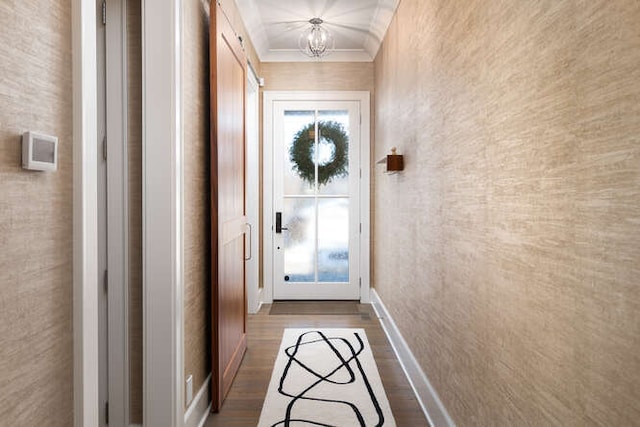 doorway to outside featuring crown molding, wood-type flooring, and a notable chandelier