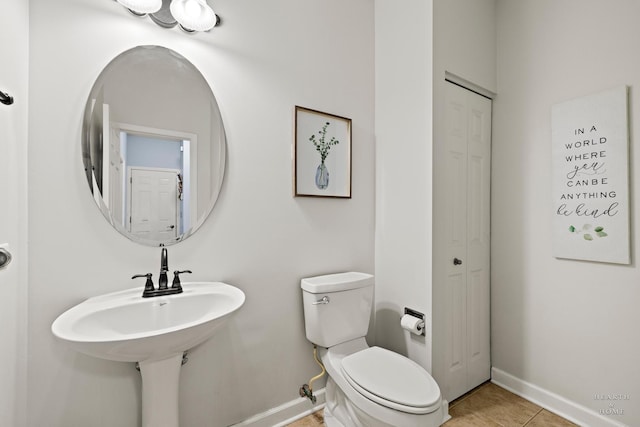 bathroom with toilet and tile patterned flooring