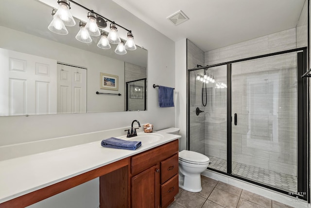 bathroom featuring an enclosed shower, vanity, toilet, and tile patterned flooring