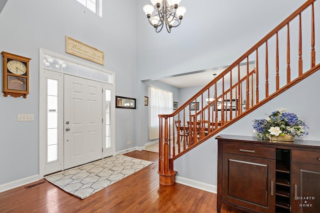 foyer entrance featuring a towering ceiling, plenty of natural light, and hardwood / wood-style floors