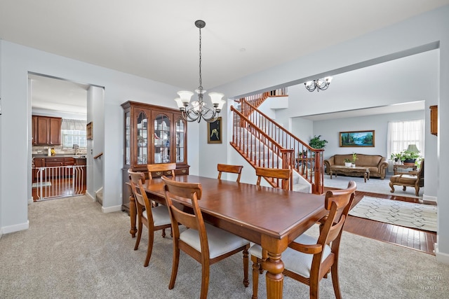 carpeted dining area featuring an inviting chandelier