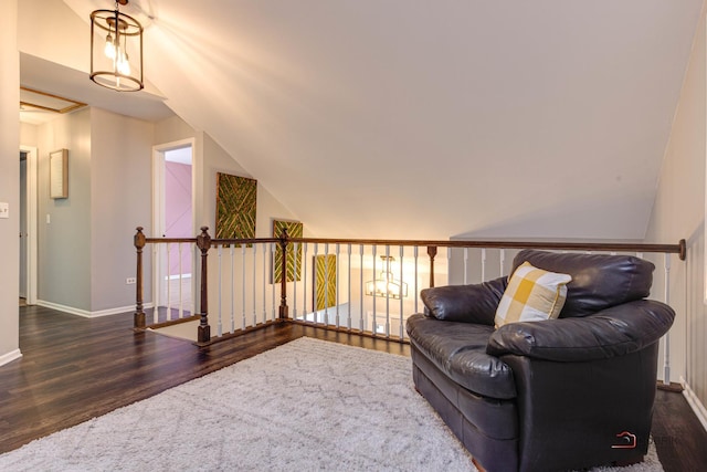 sitting room featuring vaulted ceiling and dark wood-type flooring