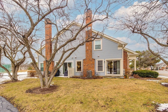 view of front of house with a front lawn and central air condition unit