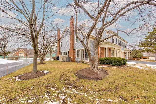 view of front of home with central air condition unit and a front yard