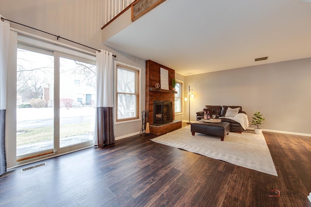 living room featuring a large fireplace and dark hardwood / wood-style flooring