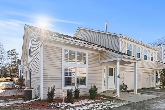 view of front of property with a garage and central AC unit