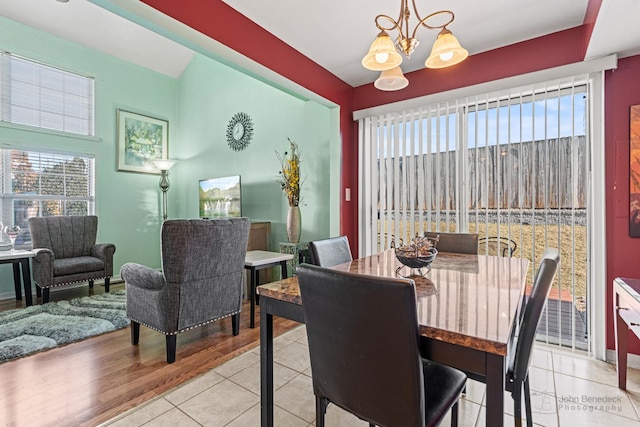 tiled dining room featuring a chandelier