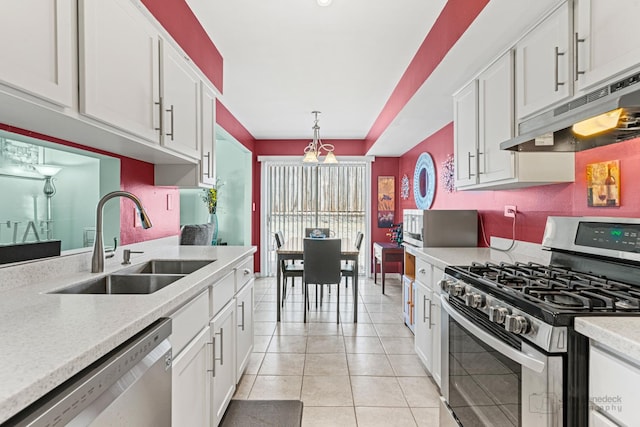 kitchen with sink, stainless steel appliances, white cabinetry, and hanging light fixtures