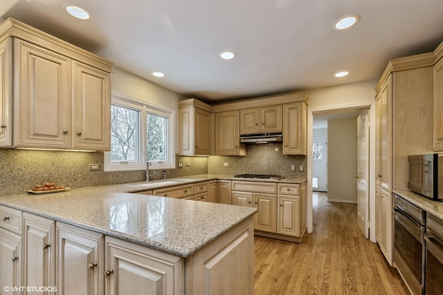 kitchen with light brown cabinetry, sink, stainless steel gas cooktop, and light wood-type flooring