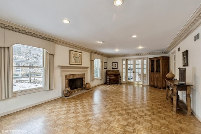 unfurnished living room featuring a fireplace, ornamental molding, french doors, and light parquet flooring