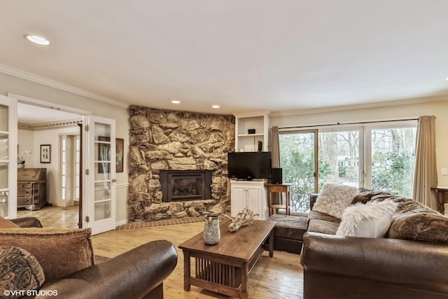 living room with light hardwood / wood-style flooring, crown molding, and a fireplace