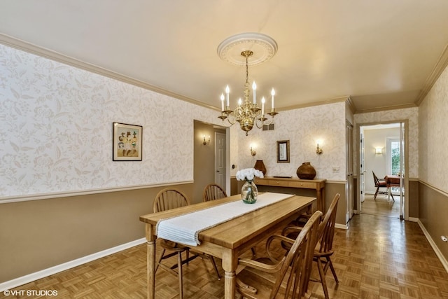 dining space with ornamental molding, parquet flooring, and a chandelier