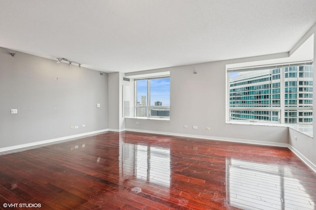 spare room with dark wood-type flooring and a textured ceiling