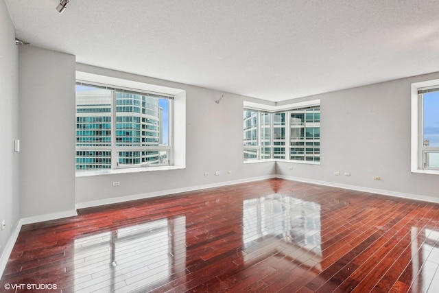 unfurnished room featuring a textured ceiling and dark hardwood / wood-style floors