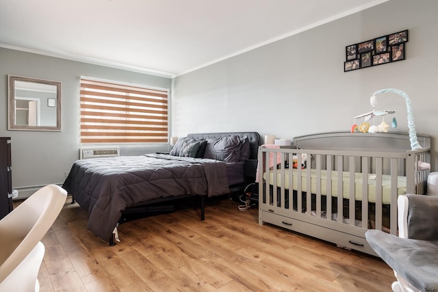 bedroom with ornamental molding and light wood-type flooring