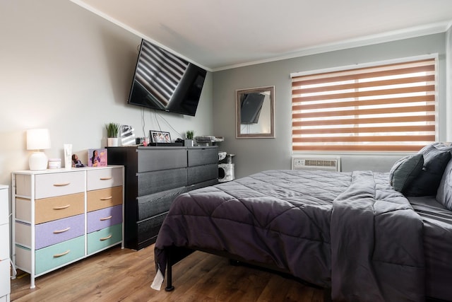 bedroom with hardwood / wood-style floors and ornamental molding