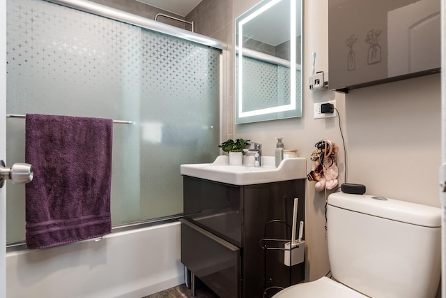 full bathroom with toilet, enclosed tub / shower combo, and vanity