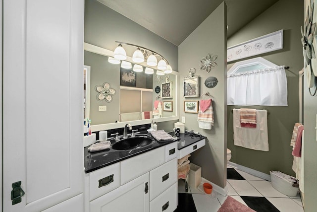 bathroom featuring toilet, vanity, vaulted ceiling, and tile patterned floors