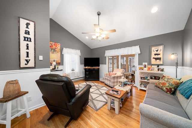 living room featuring ceiling fan, lofted ceiling, a baseboard heating unit, and hardwood / wood-style floors