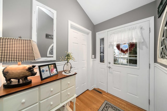 foyer with light hardwood / wood-style flooring and lofted ceiling