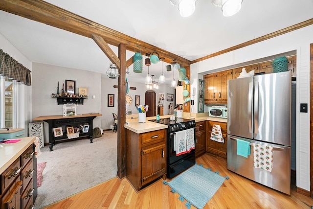 kitchen featuring pendant lighting, black range with electric stovetop, light carpet, stainless steel fridge, and kitchen peninsula