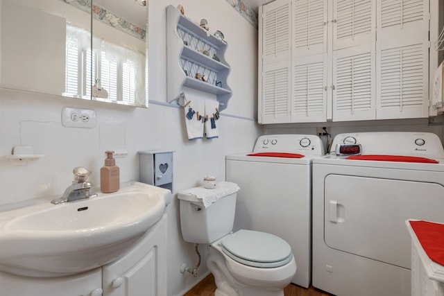 bathroom featuring separate washer and dryer, sink, and toilet