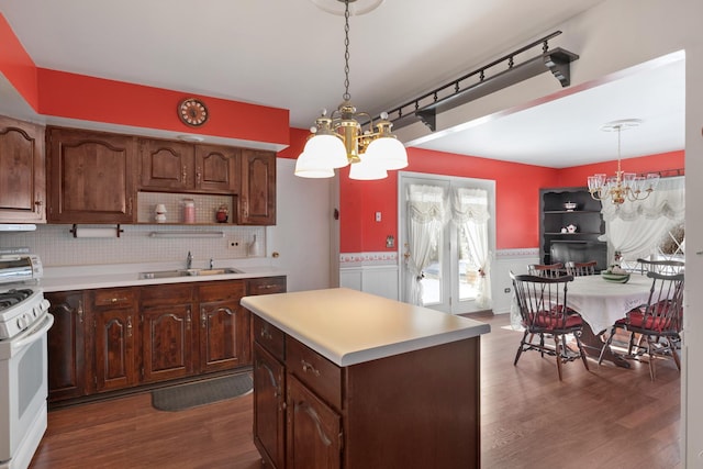 kitchen featuring sink, hanging light fixtures, a notable chandelier, and independent washer and dryer